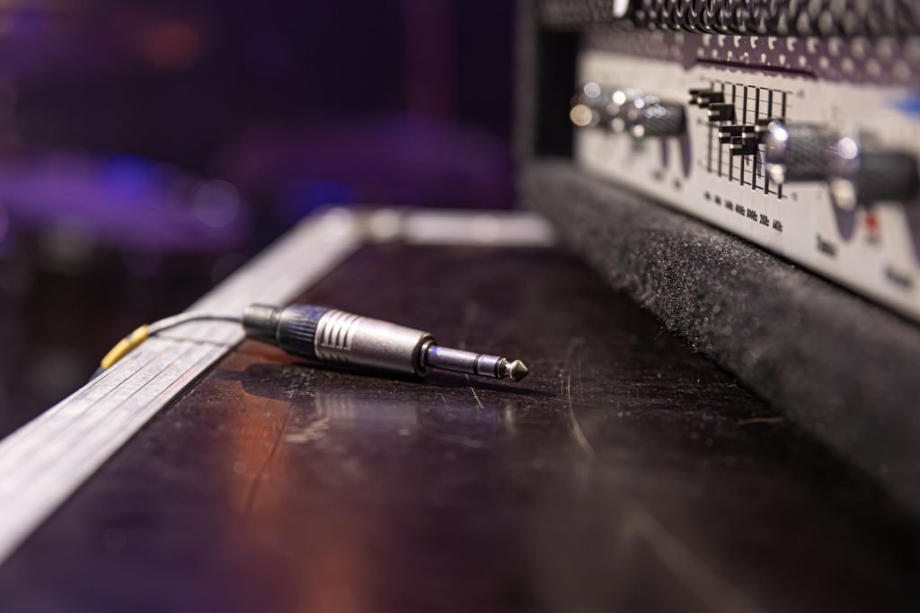 Cable de audio conectado a un equipo de sonido profesional. Kovak Collective historia: pasión por la música electrónica y el compromiso con la calidad en cada conexión.